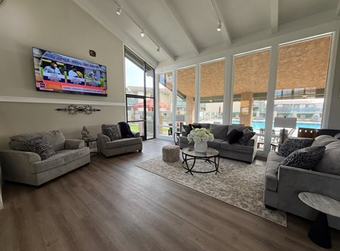 A living room with a flat screen TV mounted on the wall.
